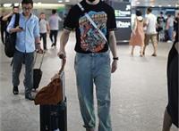 王嘉现身机场，他戴着小红帽，穿着动漫黑T显宅男属性