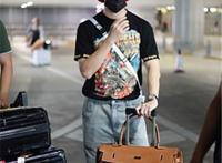 王嘉现身机场，他戴着小红帽，穿着动漫黑T显宅男属性