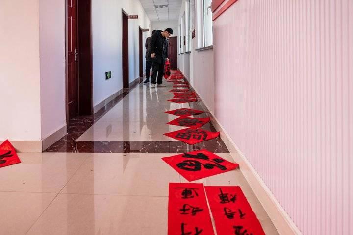 志愿者走进乡村送福，写春联拍全家福