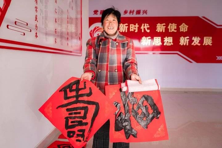 志愿者走进乡村送福，写春联拍全家福