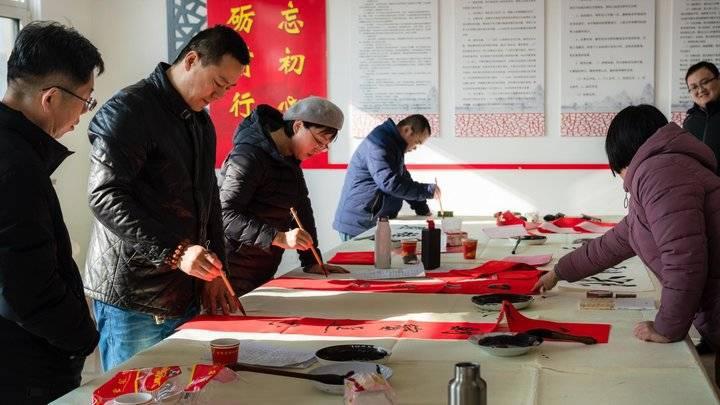 志愿者走进乡村送福，写春联拍全家福