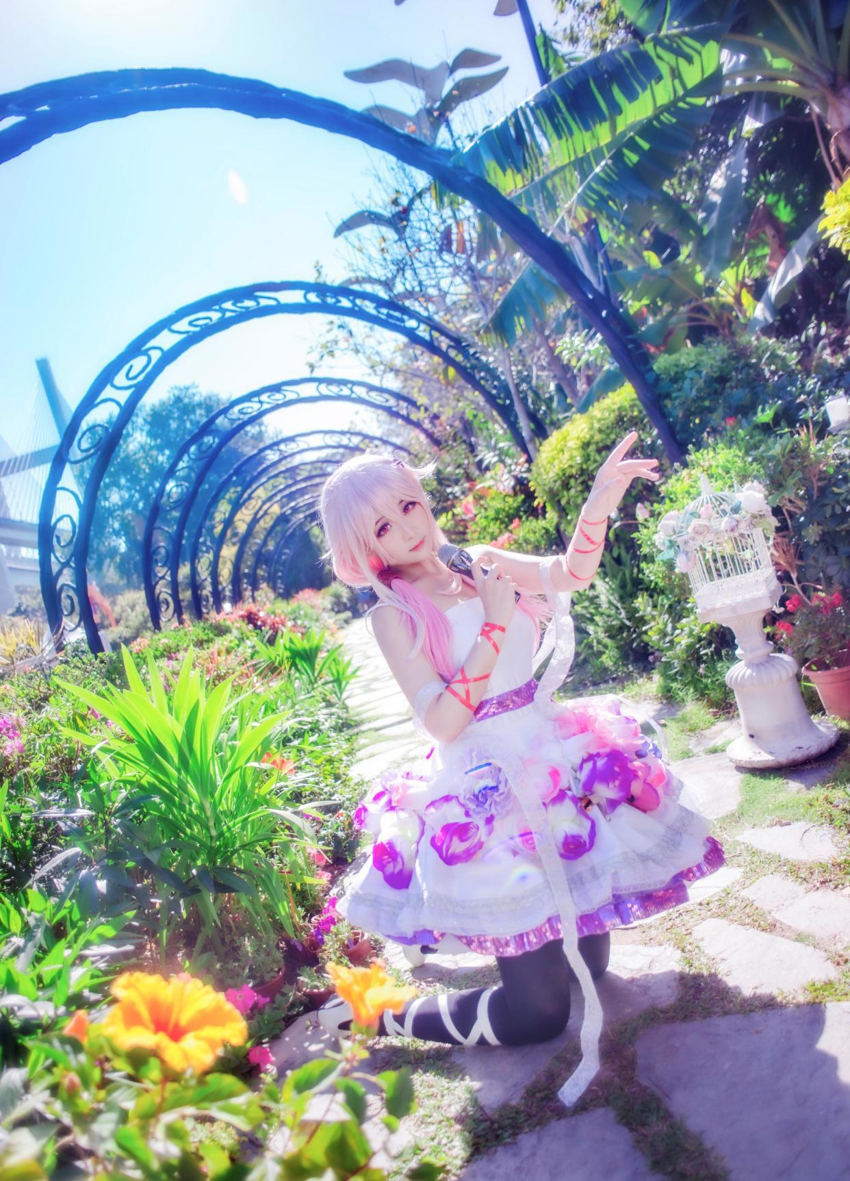一片花丛间少女cos的楪祈，拿着话筒的她似乎想要唱首歌给你听
